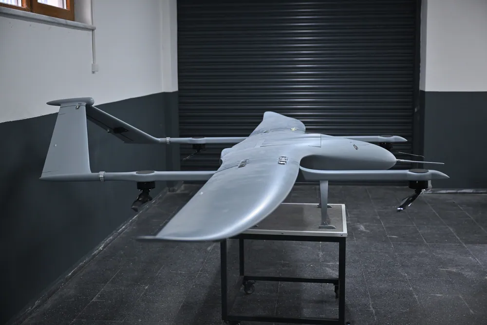 SkyCopes VTOL UAV on its stand in the hangar, showing the nose, wing root and a lift rotor boom