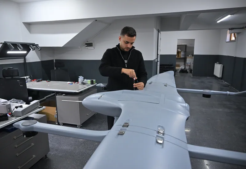 An engineer working on the wing of a SkyCopes aircraft in the workshop